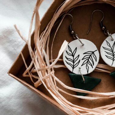 Close-up of handcrafted leaf-design earrings in a rustic gift box, perfect for nature lovers.